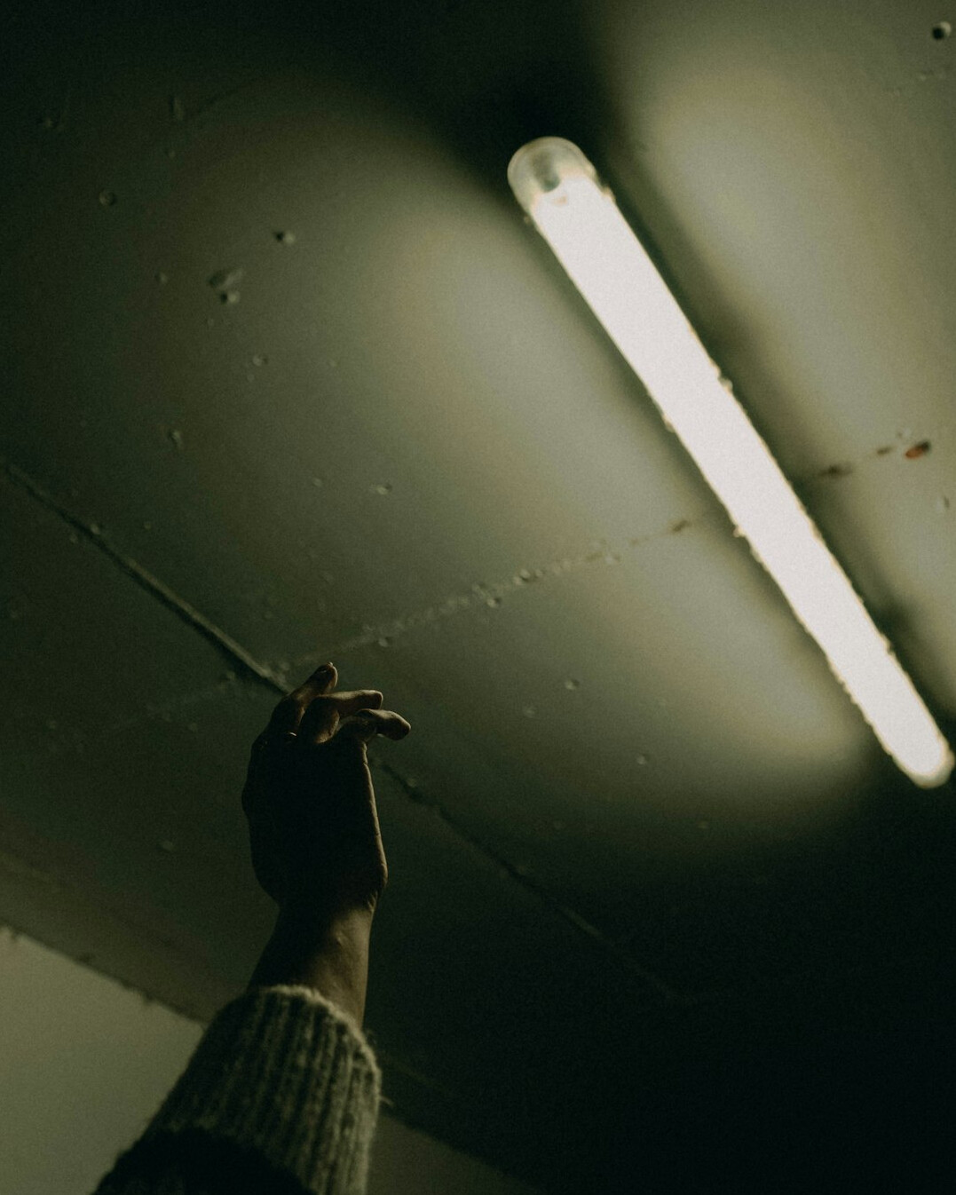 Hand reaching toward a glowing lightbulb symbolizing an idea